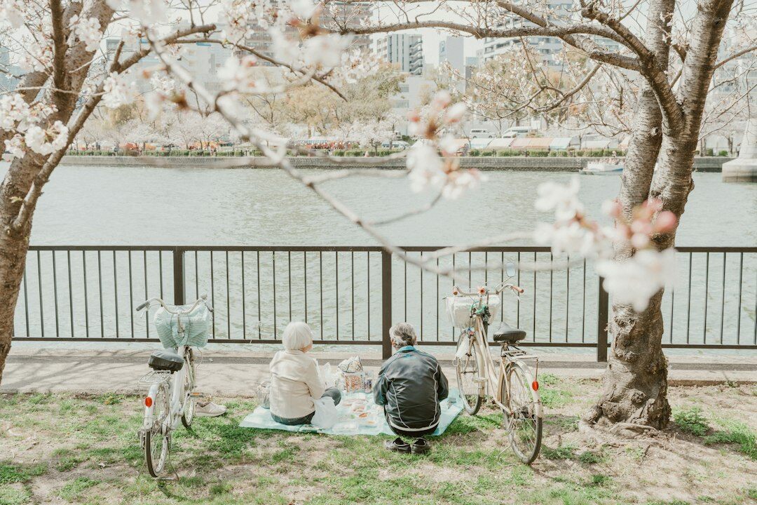 Group of smiling Japanese seniors laughing together outdoors in a park
